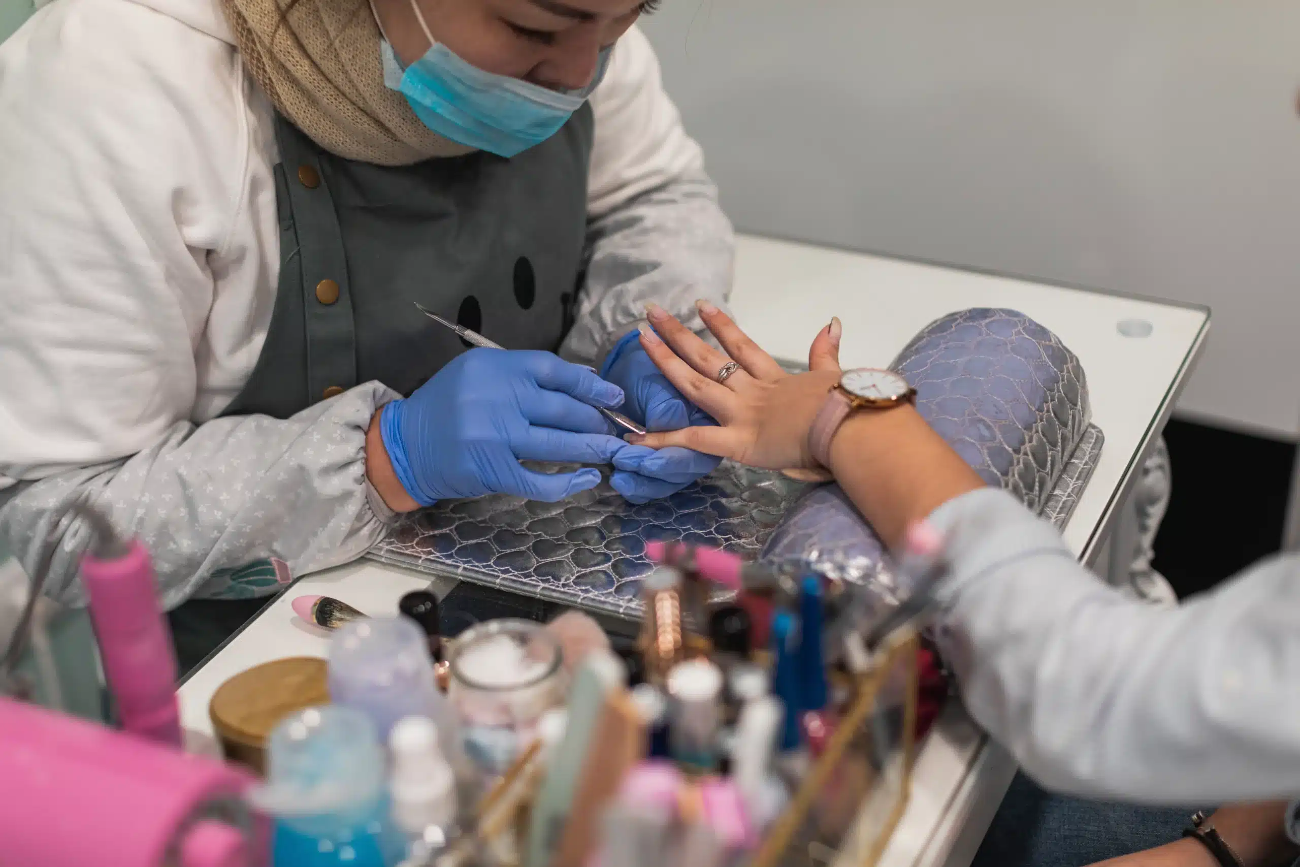 Nail artist applying nail polish for a client at Angel Nail & Beauty Lab.